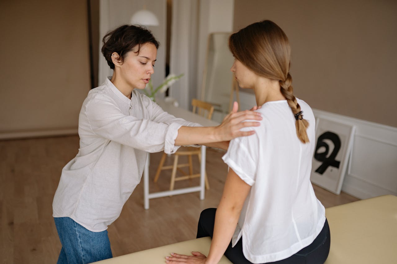A massage therapist works with a client in a calming indoor setting.